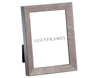 May include: A light gray wood picture frame with a black border. The frame has a slightly distressed look and the text "LUCY FRAMES" is printed on the front.
