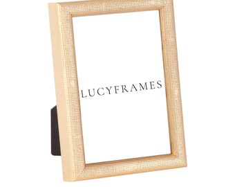 May include: A gold picture frame with a textured surface. The frame is made of wood and has a simple design. The frame is 4x6 inches in size.