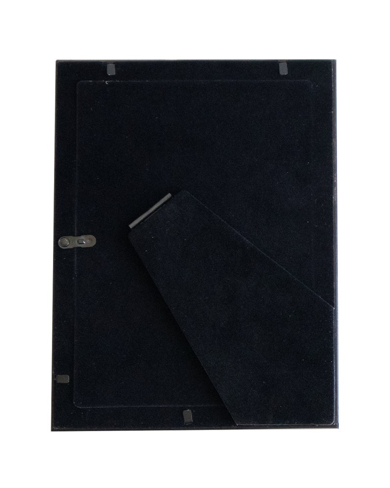 May include: Black picture frame with a black mat and a stand on the back.