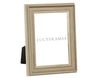 May include: A light gray picture frame with a distressed finish and a double mat. The frame is made of wood and has a simple design. The frame is standing on a white surface. The text "LUCYFRAMES" is printed on the frame.