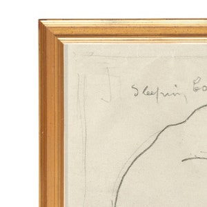Puede incluir: Un dibujo a lápiz de un rostro dormido enmarcado. El dibujo está sobre un fondo blanco y el marco es de madera marrón claro.