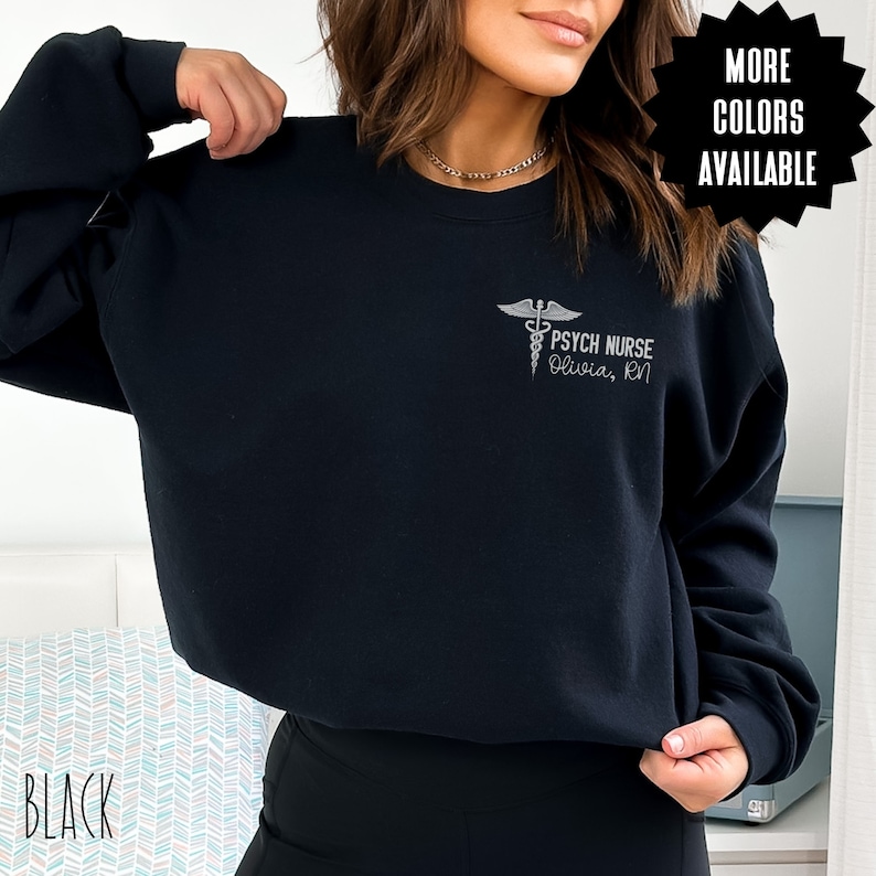 May include: Black sweatshirt with a white graphic of a caduceus and the text "Psych Nurse Olivia, RN".
