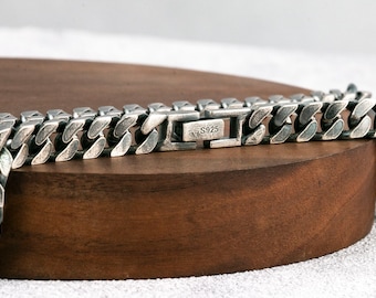 May include: A silver curb chain necklace with a clasp marked "S925".