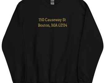 May include: Black sweatshirt with gold text that reads "150 Causeway St Boston, MA 02114"