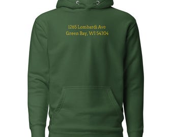 May include: A dark green hoodie with a front pocket and drawstring hood. The text "1265 Lombardi Ave Green Bay, WI 54304" is printed in yellow on the front. The hoodie is made of a soft material.