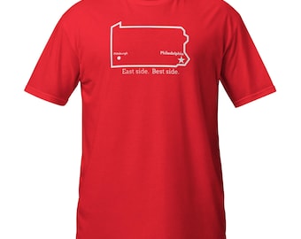 May include: A red t-shirt featuring a white outline of the state of Pennsylvania. The shirt includes the cities of Pittsburgh and Philadelphia, with the text "East side. Best side."