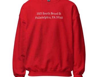 May include: Red sweatshirt with white text that reads "3501 South Broad St Philadelphia, PA 19148"