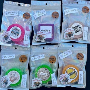 May include: Assortment of air fresheners in clear plastic bags. The fresheners are round and square, with various colors and text, including "Your crazy is showing" and "Let the gains begin". Each bag has a "thank you" sticker.