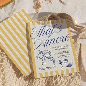 May include: A bridal shower invitation with a yellow and white striped border. The invitation features the text "That's Amore" in blue script, along with details about the event, including the date, time, and location. A lemon illustration is also included.