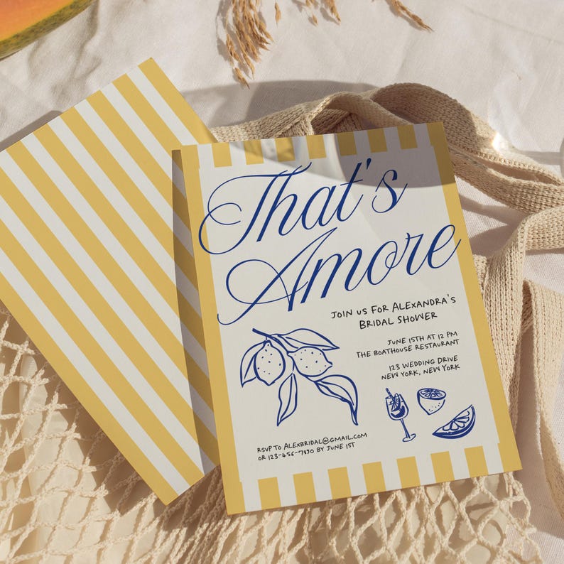 May include: A bridal shower invitation with a yellow and white striped border. The invitation features the text "That's Amore" in blue script, along with details about the event, including the date, time, and location. A lemon illustration is also included.