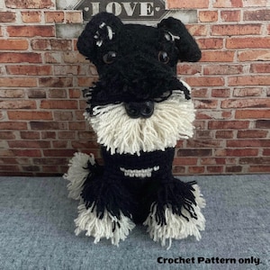 Peut inclure: Jouet en crochet miniature schnauzer noir et blanc. Le chien a une barbe blanche et du poil blanc autour des pattes.