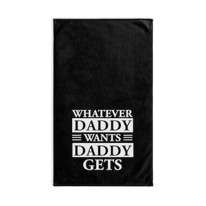 Könnte beinhalten: Schwarzes Strandtuch mit weißem Text, der "Whatever Daddy Wants Daddy Gets" lautet.