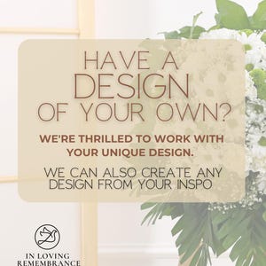 May include: A floral arrangement with white and green flowers, and large green leaves. A sign with the text "HAVE A DESIGN OF YOUR OWN?" and "IN LOVING REMEMBRANCE" is in the foreground.