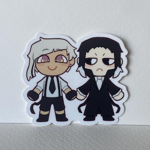 May include: A sticker featuring two cartoon characters. One character has white hair, a white shirt, black tie, and black shorts. The other character has black hair and a black coat. Both characters are holding hands.