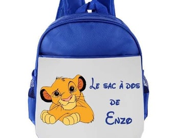 Könnte beinhalten: Blauer Rucksack mit einer weißen Vorderseite, auf der ein Comic-Löwenjunges und der Text "Le sac à dos de Enzo" abgebildet sind.
