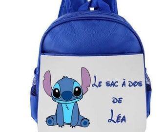Könnte beinhalten: Blauer Rucksack mit einer weißen Vorderseite, auf der ein Zeichentrick-Stitch-Charakter und der Text "Le sac à dos de Léa" abgebildet sind.