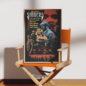 May include: A rectangular film poster titled Sinners Dance with the Devil featuring a dark colour palette with red and blue accents. The poster displays multiple figures, including a man in a flat cap, and lists cast names like Michael B. Jordan.