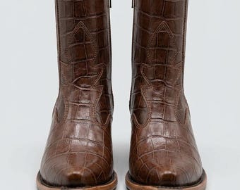 Botas de cano curto estilo western em imitação de crocodilo marrom, botinhas de cowboy com bico fino e zíper lateral.
