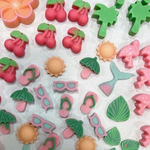 May include: Assortment of colorful, handmade, polymer clay charms with summer themes.  The charms include flip flops, sunglasses, palm trees, flowers, and umbrellas.