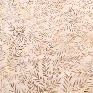 May include: A white fabric with a brown floral pattern. The pattern features leaves and flowers.
