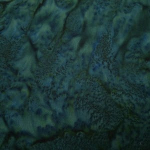 May include: A close-up of a dark teal fabric with a mottled, marbled pattern. The fabric has a soft, textured surface.