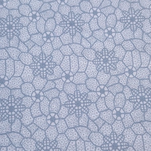 May include: A white fabric with a repeating pattern of blue floral designs. The fabric has a subtle texture.