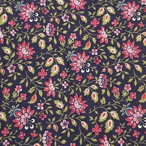 May include: Close-up of a fabric with a dark blue background and a floral pattern. The pattern features red and pink flowers, small red blossoms, and green leaves. The design is a repeating pattern.