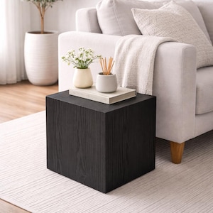 May include: A trio of cream-glazed ceramic mugs with a speckled finish. Each mug is adorned with a hand-painted design: a blue and green leaf, a yellow flower, and a red berry. The mugs have a simple, rounded form.