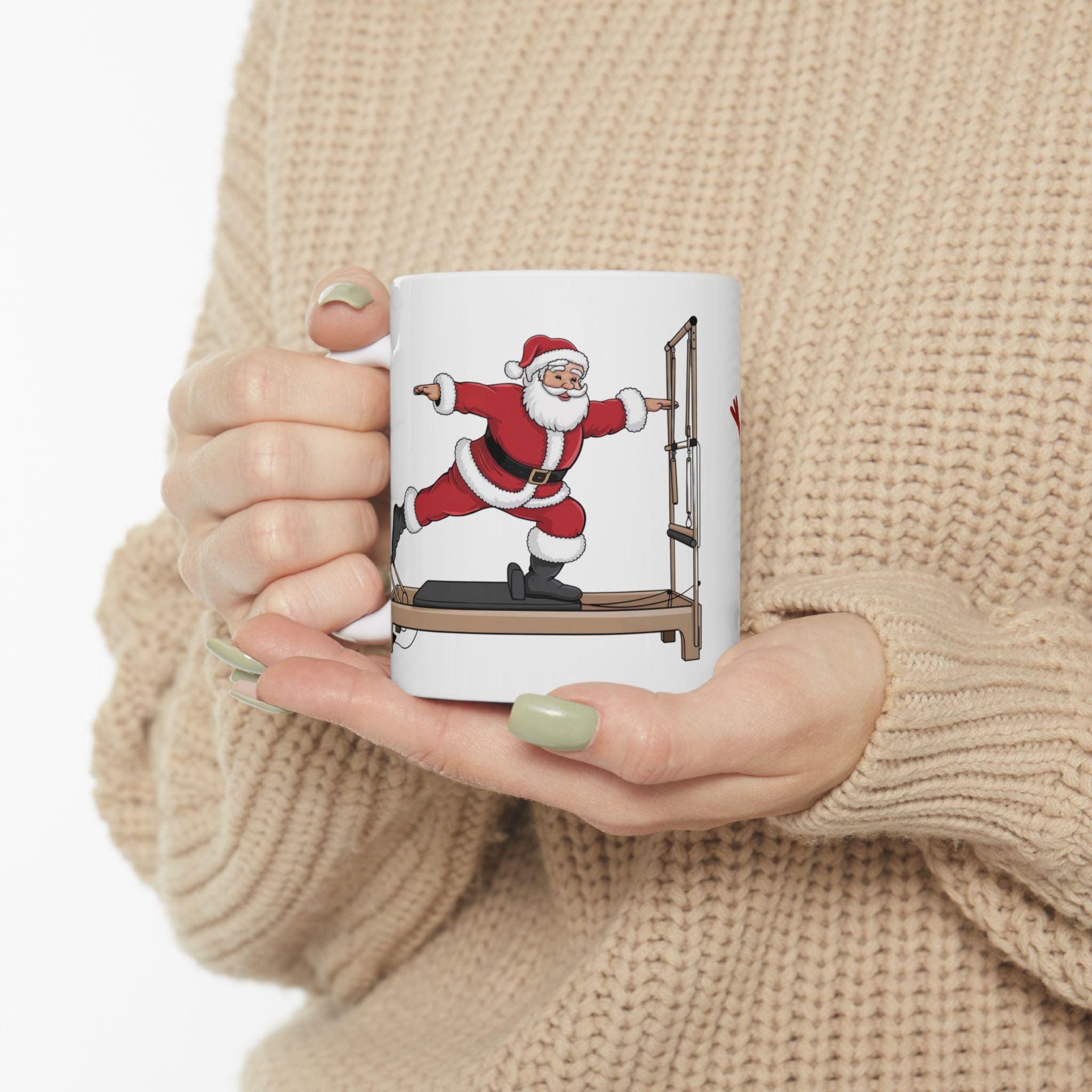 Pilates Christmas mug, Pi-LaLaLa-Tes Santa on a Pilates Reformer. Gifte Ceramic coffee cup. Festive holiday present for your instructor