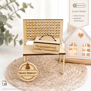 May include: A laser-cut wooden miniature bench featuring a perforated backrest and a small box with a circular saw blade design. The box is engraved with the German text 'Wo gewichtelt wird, da fallen Tannenzapfen!' and a circular sign reads 'WICHTEL WERKSTATT'.