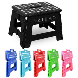 May include: A black folding step stool with white polka dots and the word "NATUMO" printed on the top. The stool is shown folded and unfolded in five different colors: blue, turquoise, red, green, and pink.