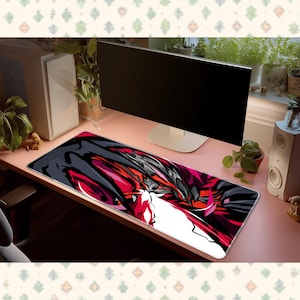 May include: A rectangular desk mat featuring a bold, abstract graphic design in shades of black, dark grey, white, and vibrant red. The surface displays sharp, angular shapes and flowing lines that create a dynamic, high-contrast visual pattern.