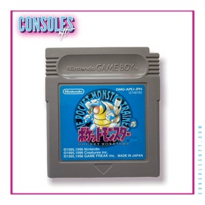 Puede incluir: Un cartucho de Game Boy gris con una etiqueta azul y blanca. La etiqueta presenta una caricatura de una criatura azul y amarilla similar a un dinosaurio con el texto "Pocket Monsters" en japonés e inglés.