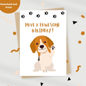 May include: A white card with a brown border and paw prints along the top. The card says "Have a PAWESOME BIRTHDAY!" and features a cartoon beagle dog with brown and white fur, waving with its right paw.