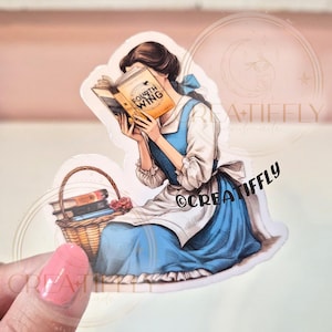 May include: A sticker featuring a woman in a blue dress reading a book titled "Fourth Wing." A basket of books and a rose are next to her. The sticker has a white border and a watercolor style.