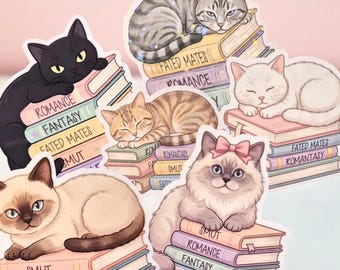 May include: A collection of six die-cut stickers featuring various cats resting on stacks of books. The books have spines labeled with genres including Romance, Fantasy, Fated Mates, Smut, Romantasy, and Thriller. The cats are depicted in different colors.