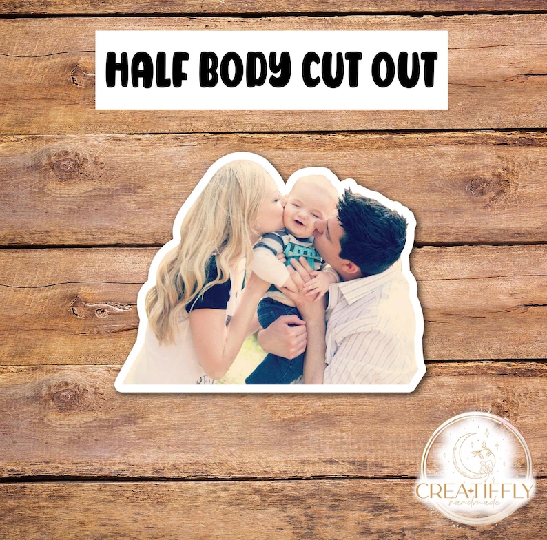 May include: A photo cutout of a family with a woman, a man, and a baby. The woman is kissing the baby on the cheek. The man is holding the baby and smiling. The baby is wearing a blue and green shirt. The family is standing in front of a green background.