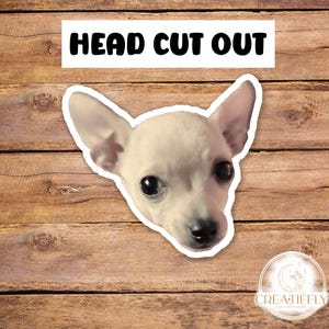 May include: A white chihuahua dog head cut out, with black eyes and a black nose. The dog is looking directly at the camera. The image is on a wood background with the text "HEAD CUT OUT" at the top.
