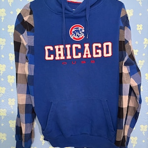 May include: A white ceramic mug with a black handle and the text "But First, Coffee" in a bold, black font. The mug is set against a blurred background, suggesting a cozy setting. The mug appears to be approximately 4 inches tall.