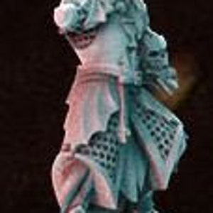 May include: A miniature figurine of a man wearing a long, flowing robe with a detailed pattern. He is holding a book in his left hand and a staff in his right hand. The figurine is painted in shades of blue and green, with a hint of pink on the robe. The figurine is standing on a base of books.