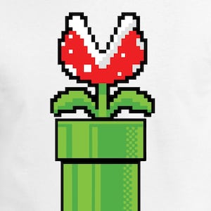 May include: White t-shirt with a pixelated graphic of a red and white Piranha Plant from a green pipe. The design is inspired by a classic video game character. The shirt is made of a soft, comfortable material.
