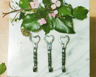 Hand forged heart hooks with twist.