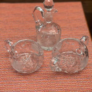 Antique crystal cruet, creamer, and sugar 3 piece set. McKee Glass Innovation #410 Daisy and Button clear glass with a sawtooth rim