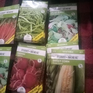 May include: Assortment of Ferry-Morse vegetable seed packets. Varieties include carrots, green beans, salad blend, radishes, and sweet corn. Each packet features a picture of the vegetable and the number of seeds.
