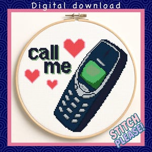 Op de afbeelding: Kruissteekontwerp in een houten hoepel met een retro mobiele telefoon, de woorden "call me" in groen en zwart en rode hartsymbolen. De woorden "Digital download" en "Stitch Please!" zijn ook zichtbaar.