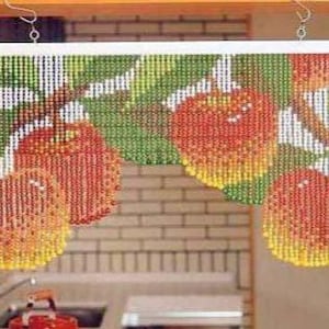 May include: A beaded curtain featuring a design of red and yellow apples hanging from green leaves. The curtain is suspended from a white rod with silver hooks, adding a decorative touch to a doorway or window.