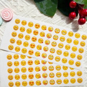 May include: A sheet of yellow smiley face stickers with various expressions, including winking, hearts, and tongues sticking out. The stickers are on a white background.