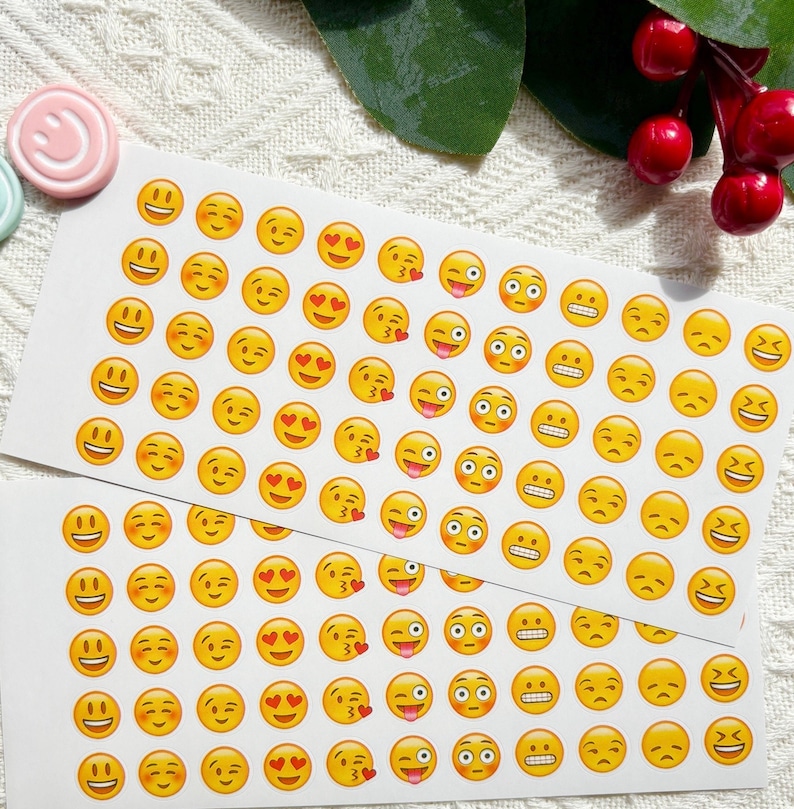 May include: A sheet of yellow smiley face stickers with various expressions, including winking, hearts, and tongues sticking out. The stickers are on a white background.