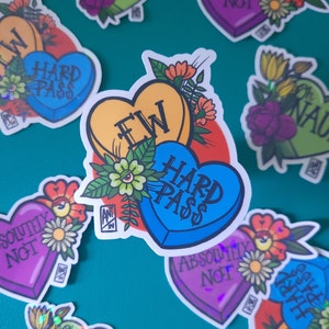 May include: A set of colorful heart-shaped stickers with various phrases, including "Hard Pass", "EW", and "Absolutely Not". The stickers feature floral designs and are perfect for adding a touch of personality to your belongings.