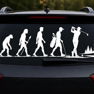 May include: A white vinyl decal applied to a car rear window, featuring a graphic evolution sequence. The design shows the progression from a primate to a human carrying a golf bag, ending with a figure swinging a golf club toward a flag on a green.